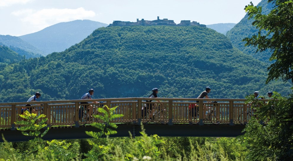Ciclisti in fila indiana su un ponte della ciclabile dell’Adige in una foto di Ronny Kiaulehn